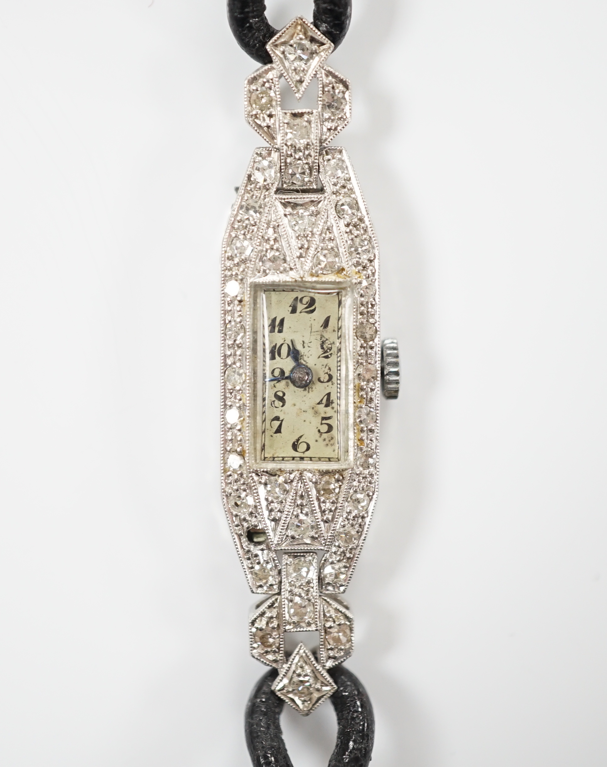 A lady's white metal (engraved platinum) and diamond cluster set manual wind cocktail watch, on a leather strap.